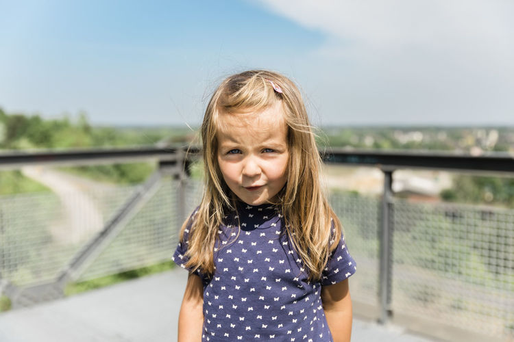 Portrait of girl standing against blurred background