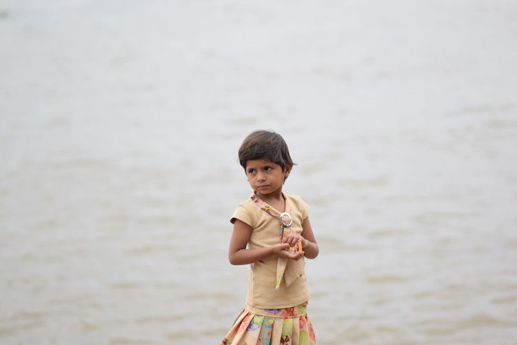 Portrait of cute boy standing in water
