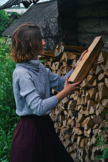 A girl collects logs to light a fire. village. belarus 