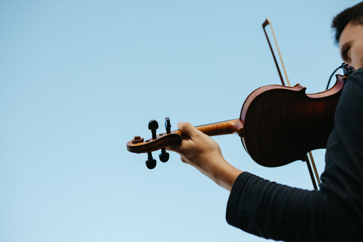 Cropped image of violin against clear sky