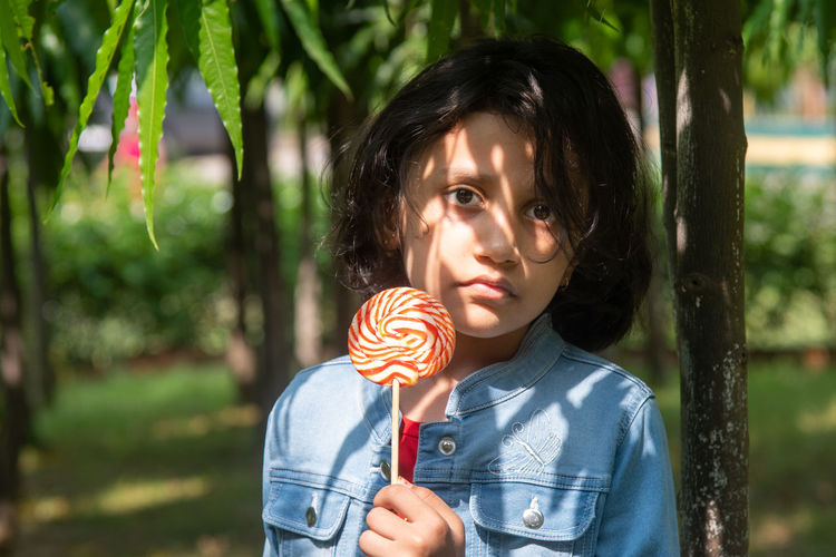 Portrait of girl holding candy