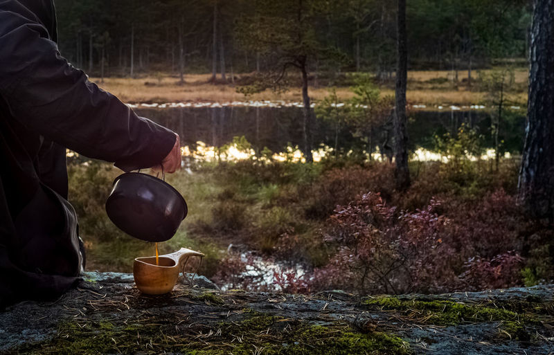 Man holding food on field in forest