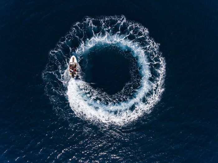 Directly above shot of boat making water wake in sea