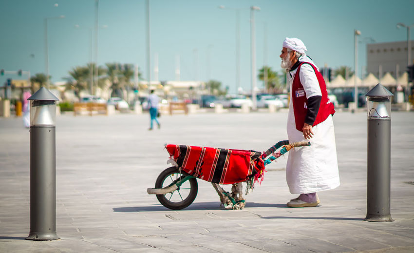 Side view of man with cart on street