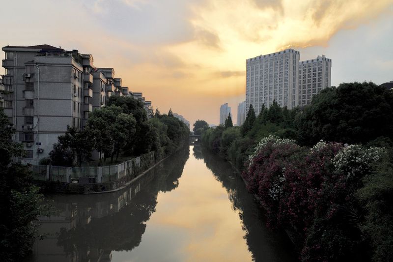 Panoramic view of buildings and river against sky during sunset