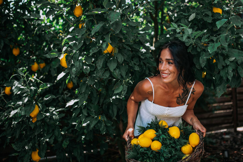 Portrait of smiling woman against orange plants