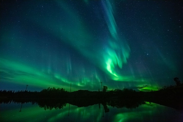 Aurora borealis is dancing above a lake at night