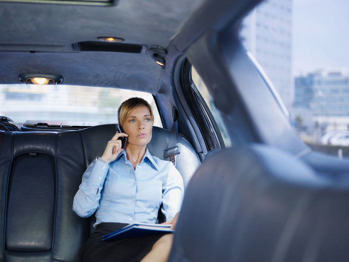 Businesswoman talking on phone while sitting in car