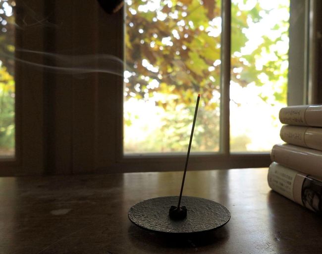 Incense burning on table at home