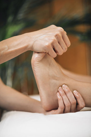 Ayurvedic reflexology foot massage, ayurveda practitioner pressing meridian points on female foot.