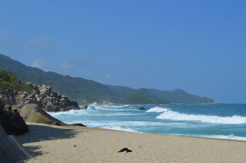Scenic view of beach against clear blue sky