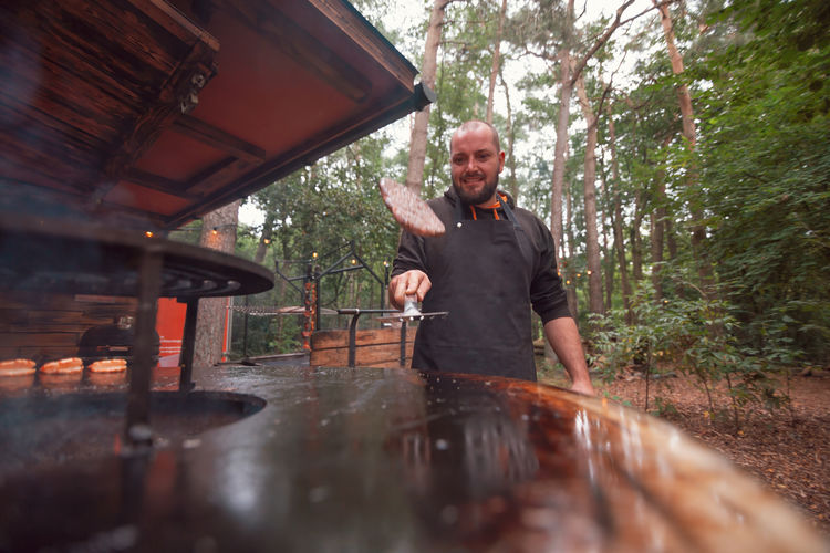 Chef in an outdoor meat restaurant cooking grilled hamburger