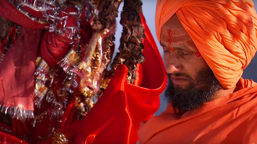 Hindu priest standing near religious offerings