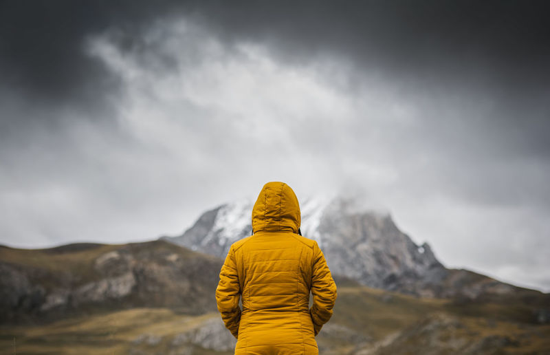 Rear view of person against mountain and sky