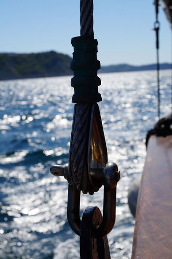 Close-up of rope tied to boat against sea