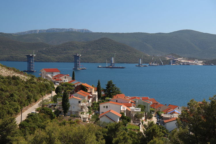 High angle view of townscape by sea against sky
