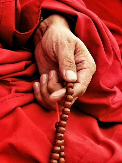 Cropped monk hand with praying beads