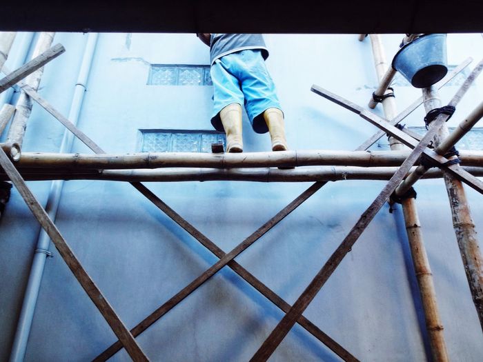 Low angle view of man standing on metal structure