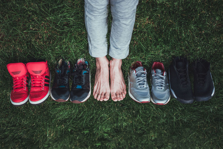 Low section of person with shoe collection on grass