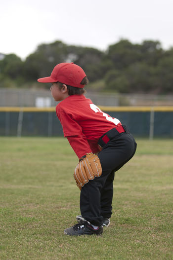 Side view of boy wearing hat on field