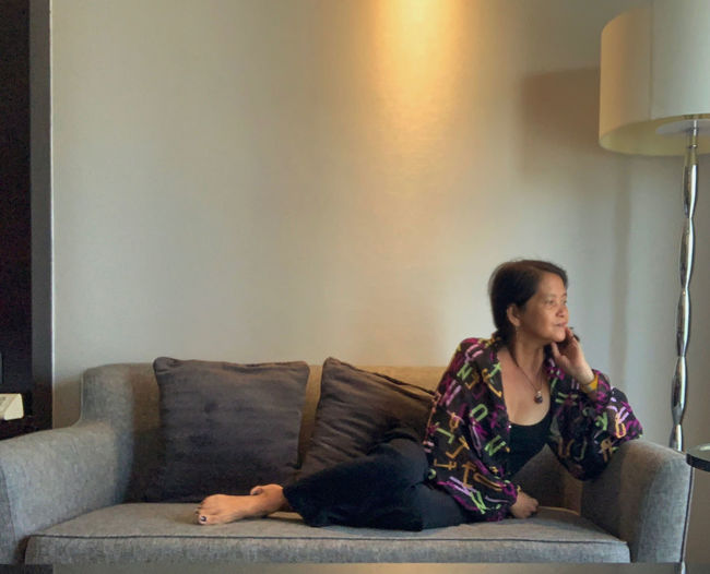 Young woman sitting on sofa at home