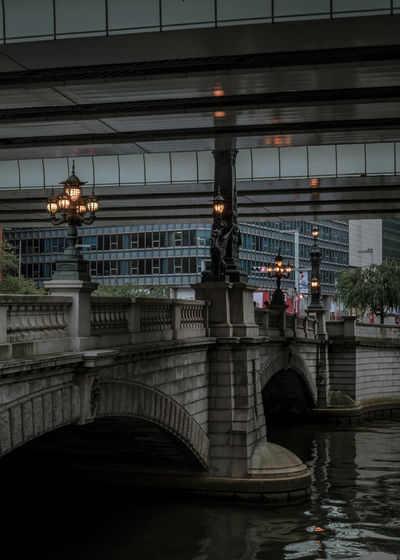 Bridge over river in city at dusk