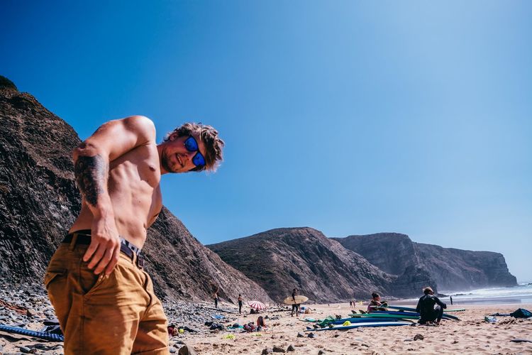 Adult Adults Only Beach Beauty In Nature Blue Clear Sky Day Leisure Activity Lifestyles Mammal Men Mountain Mountain Range Nature One Man Only One Person Only Men Outdoors People Real People Rock - Object Scenics Sky Water Young Adult