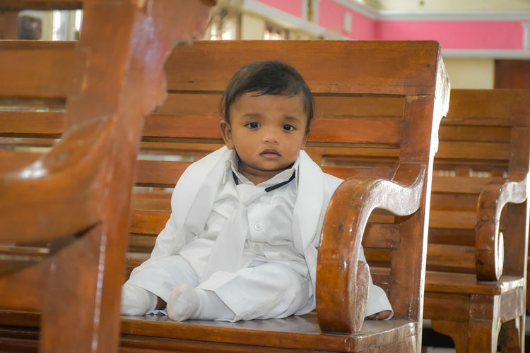 Portrait of young baby sitting on chair