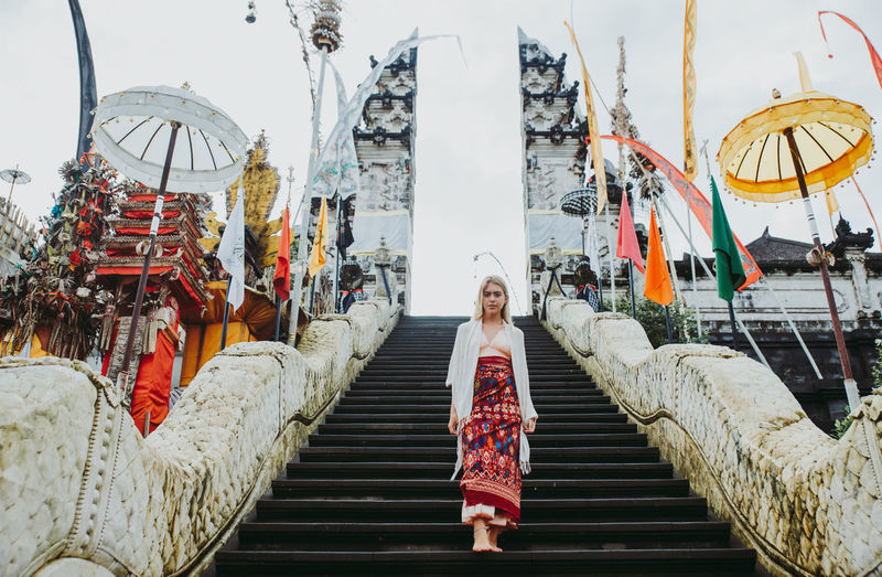 Young woman standing on staircase at temple gate