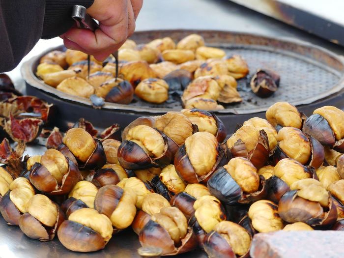 Close-up of man roasting chestnuts