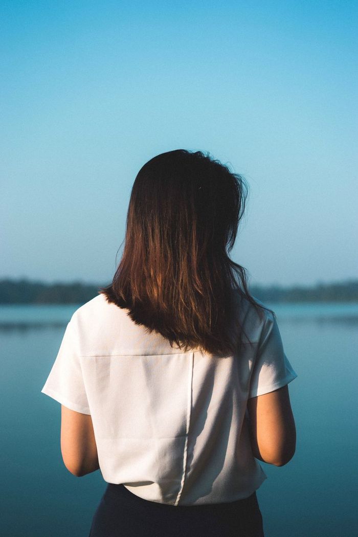 Rear view of woman standing against sea