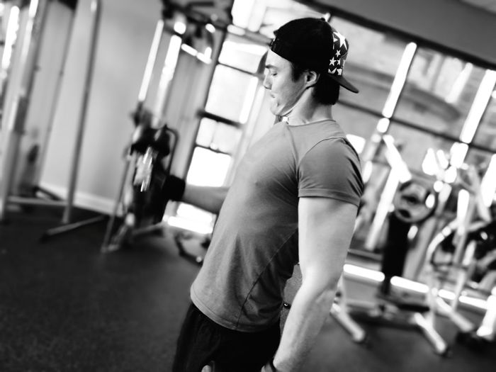 Muscular man lifting dumbbells in gym
