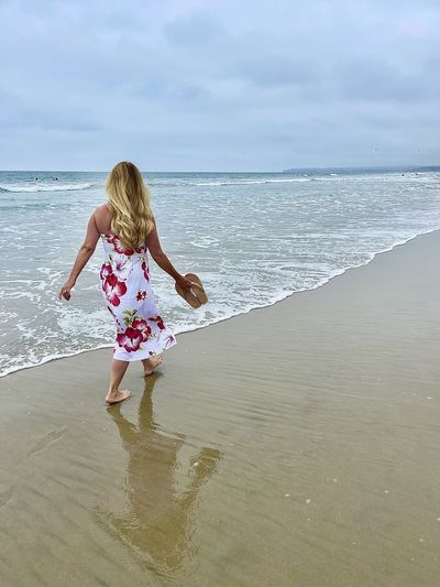 Beautiful lady walking alone on beach