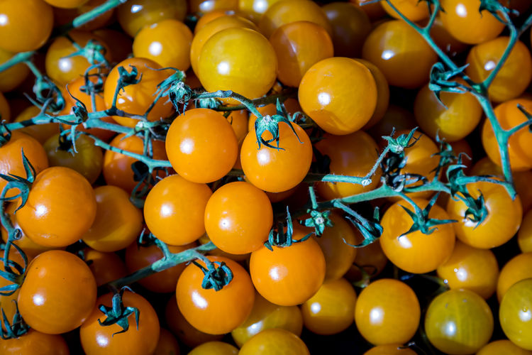 A full frame photograph of ripe cherry tomatoes for sale on a farmers market stall