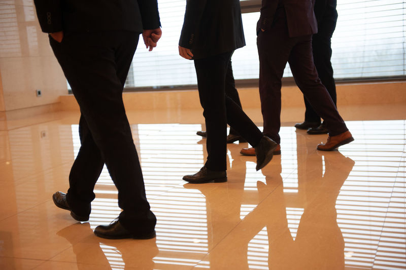 Low section of business people walking on floor