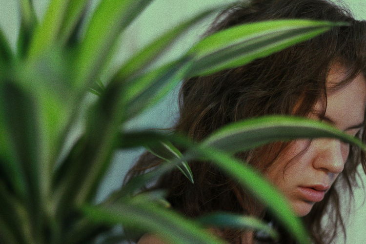 Young woman seen through plants