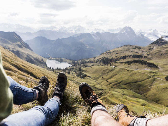 Germany, bavaria, oberstdorf, legs of two hikers resting in alpine scenery