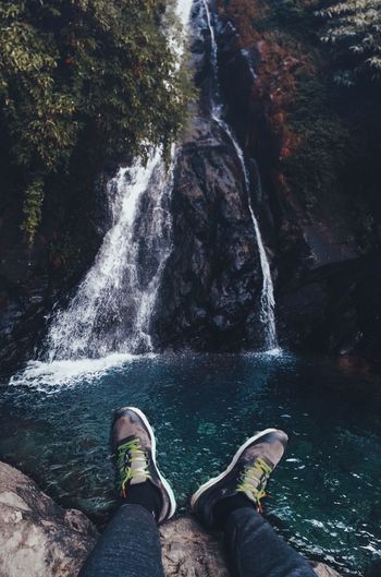 Low section of man against waterfall