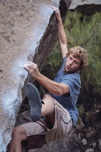 High angle view of young man bouldering