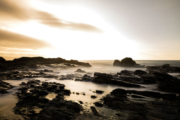 Long exposure, sea, evening light with moody clouds & rugged rocks