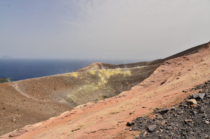 Barren landscape against calm blue sea
