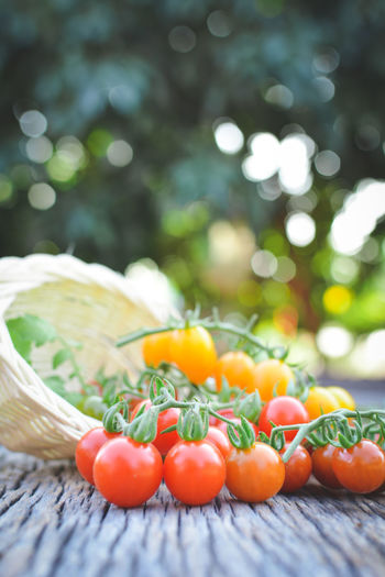Close-up of cherry tomatoes spilling from basket on table