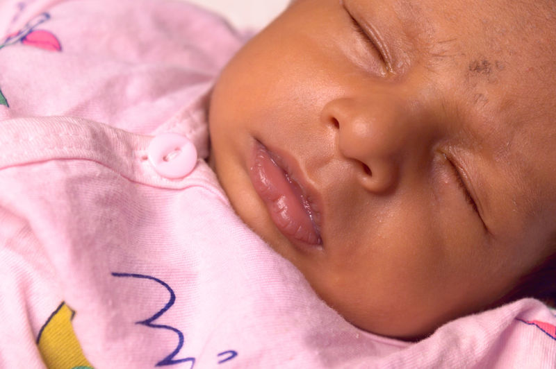 Close-up portrait of baby sleeping on bed