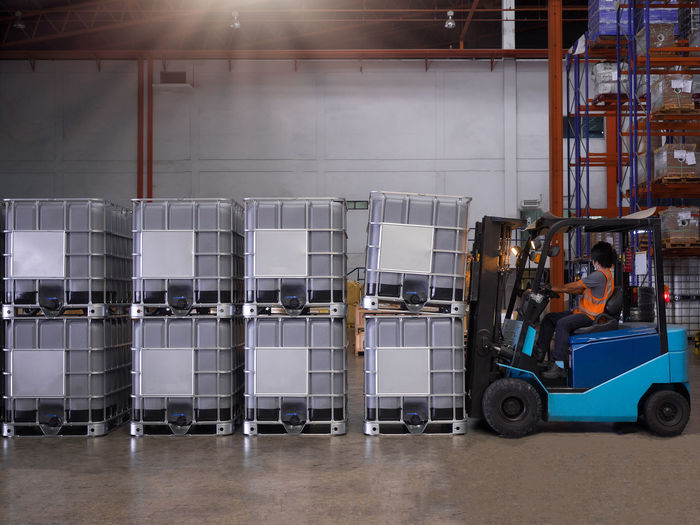 Close-up of forklift by containers