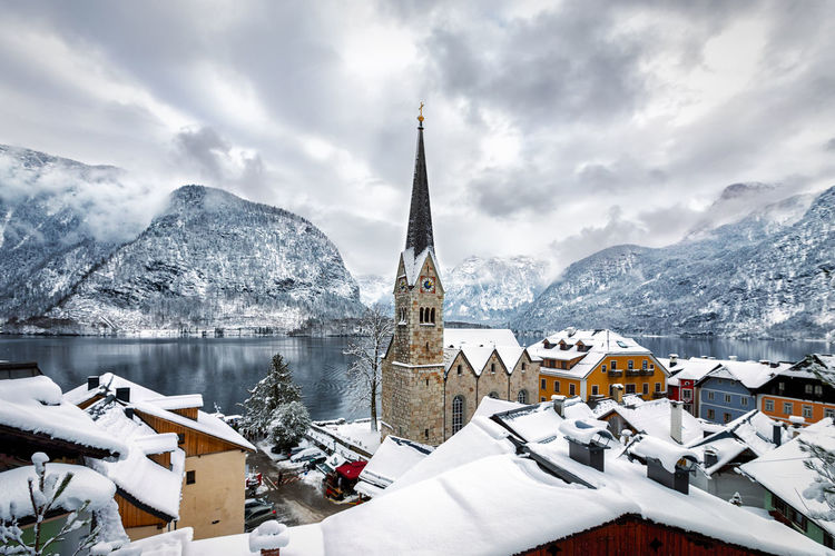 Historic church in city against mountains during winter