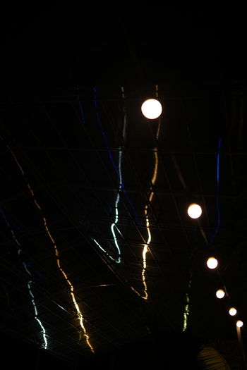 Low angle view of illuminated light bulbs on street