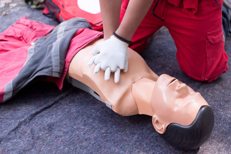 Low section of person performing cpr on dummy