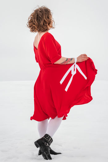 Rear view of woman standing against red background