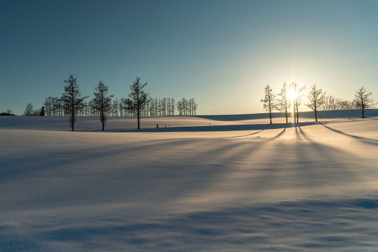 Scenic view of snow field against clear sky during winter