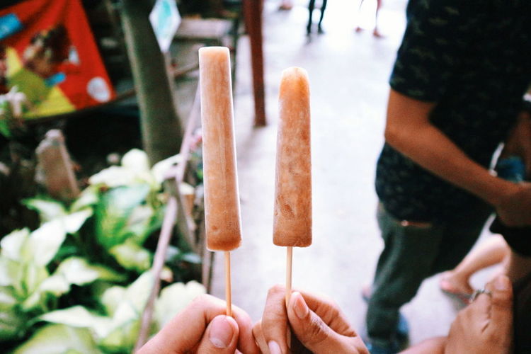 Cropped hands holding flavored ice in market